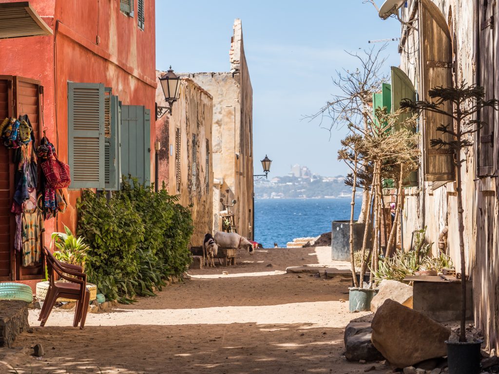 Goree, Senegal- February 2, 2019: Daily life, sandy road on the Goree island  and view of the city of Dakar Gorée. Dakar, Senegal. Africa.